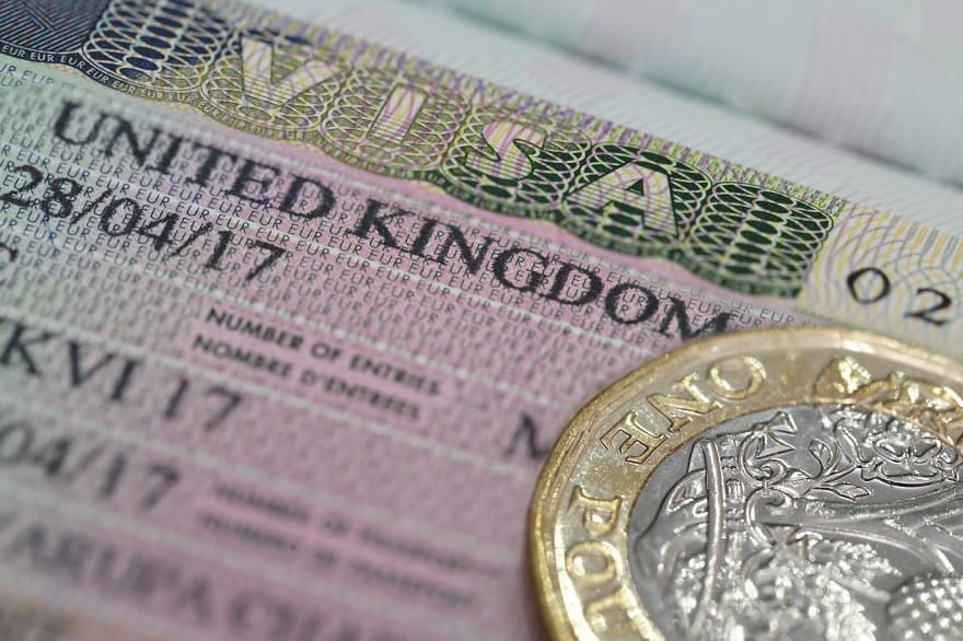 Moving to the UK - United Kingdom visa in the passport with one pounds coin